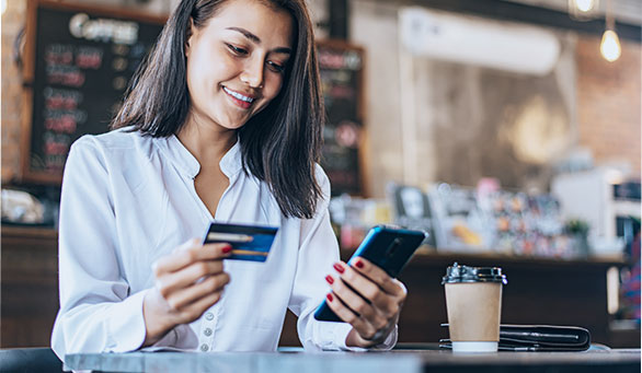 women with credit card and cell phone at coffee shop