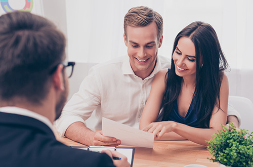young couple getting a loan approval in a credit union branch, credit union, auto loan, car loan, refinance, credit union auto loan, credit union auto refinance