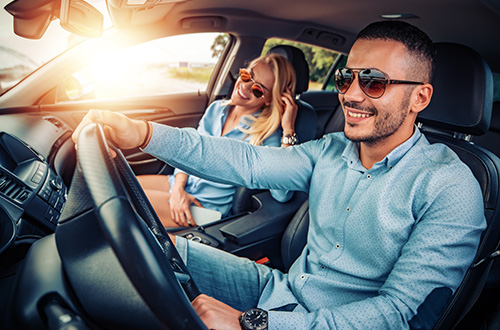 couple driving in car, happy couple smiling, sunny day, interracial couple, car, car loan, auto loan, refinance 