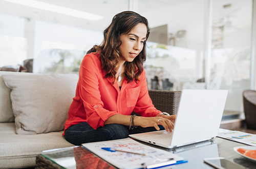 Latina woman using laptop and reviewing her finances, applying for a loan, personal loan, mortgage loan