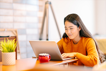 Smiling woman typing on a laptop