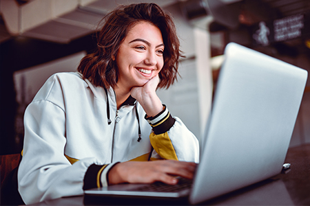 Smiling woman typing on laptop