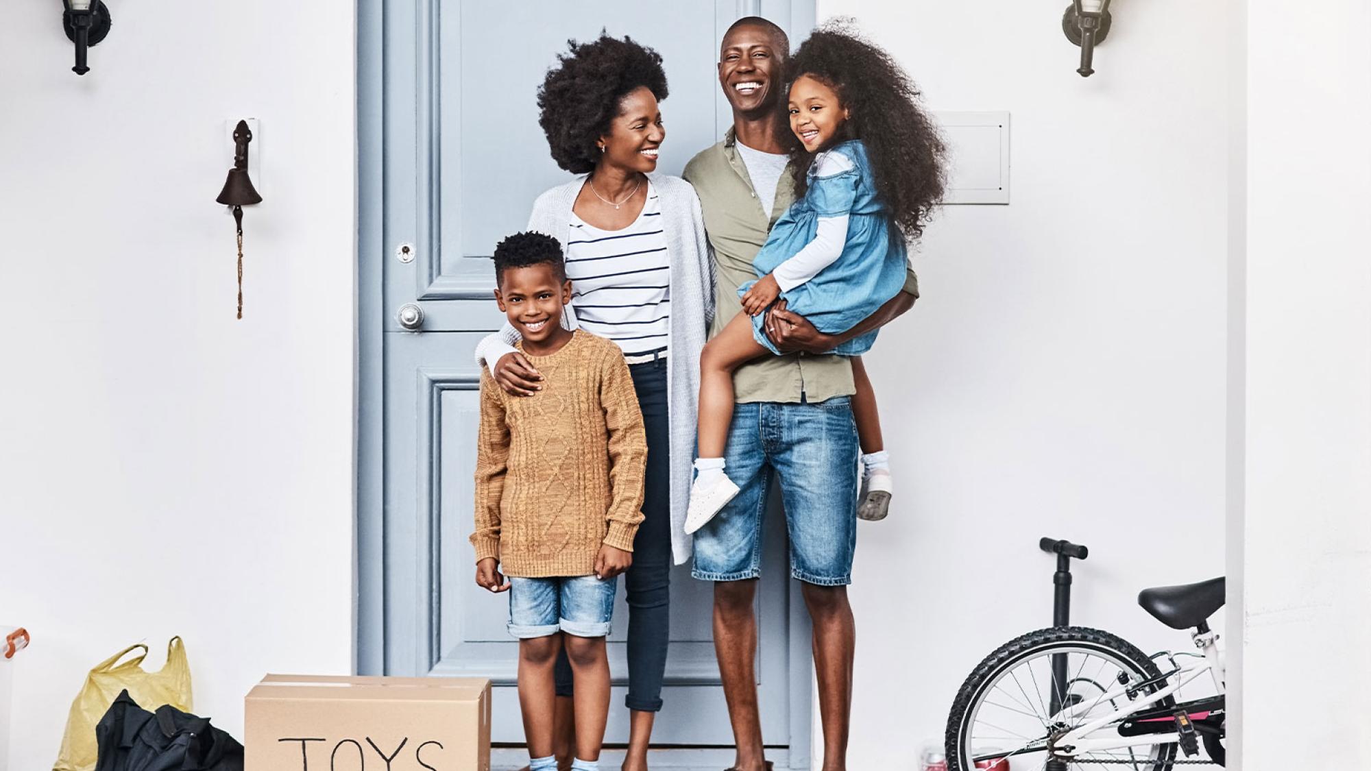 happy family standing in front of house