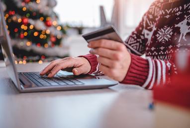 person on computer managing holiday credit debt