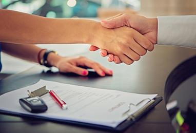 person shaking hands after buying car