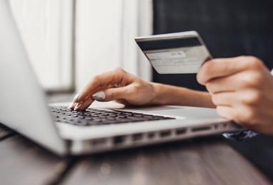 person with credit card in front of laptop, credit card budgeting