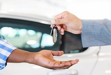 person being handed car keys after refinancing car