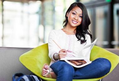 woman sitting in chair writing in notebook