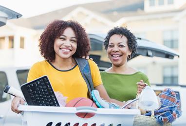 mother and daughter with dorm items moving into dorm