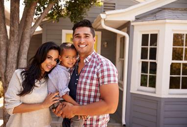 family in front of new home