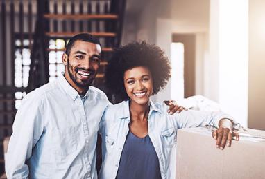 couple standing next to moving box in new home 