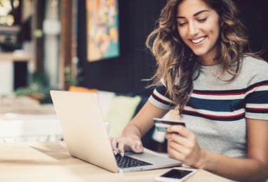 woman with credit card in front of laptop 