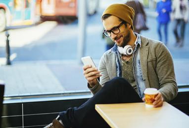 man sitting in coffee shop with cell phone
