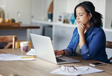 woman at kitchen table in front of laptop