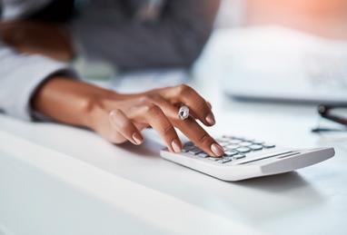 closeup of young African-American woman using a calculator, glasses, taxes, tax return, tax refund