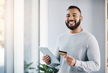 young man at home holding credit card and tablet, credit card, choosing the right credit card