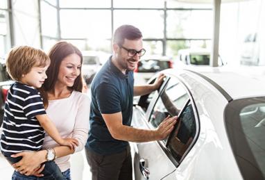 young family shopping for car at dealership, young white couple and son, car buying, buying a car, car buying cheat sheet, car buying tips, tips for buying a new