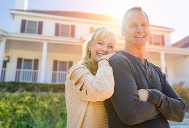 middle-aged white couple standing in front of home, home improvement, DIY, home equity, HELOC, adding value to your home