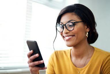 African American woman holding smartphone and smiling, smartphone, smart device, device protection, security, secure your smart devices, protect your devices, protect your information