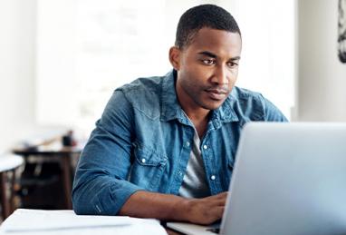 handsome young black man using laptop at home, filing taxes, tax season, tax refund, direct deposit