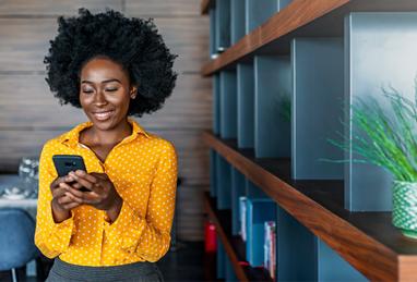 young black woman smiling and checking her phone, checking her credit score, credit scores explained 
