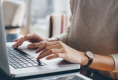 close-up of person using laptop, checking credit score