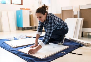 Woman doing home improvements putting nails in wood