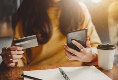 Young beautiful Asian woman using smart phone and credit card for shopping online in coffee shop café 