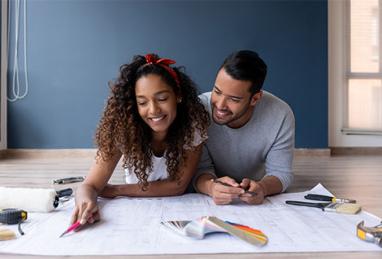 Loving couple looking at the blueprints of their new home