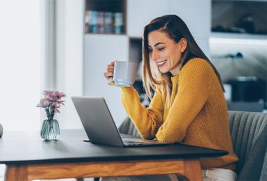 young woman working at home, typing on a laptop