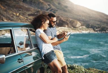 shot of a young couple using a mobile phone on a road trip 
