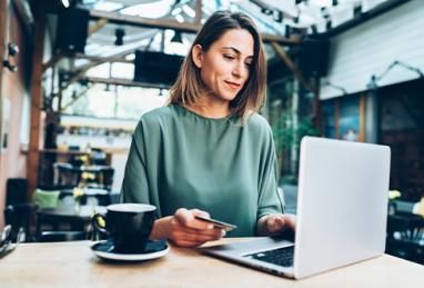 young woman shopping online in café using laptop and credit card 