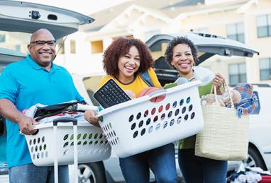 African-American parents helping their daughter move into college dorm