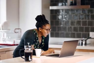 African-American woman using laptop in her kitchen