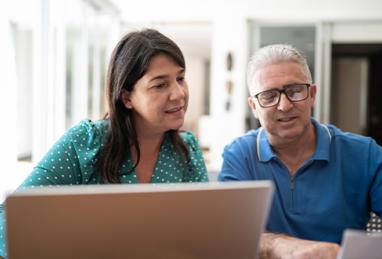 mature white couple managing their finances, reviewing their online accounts and documents