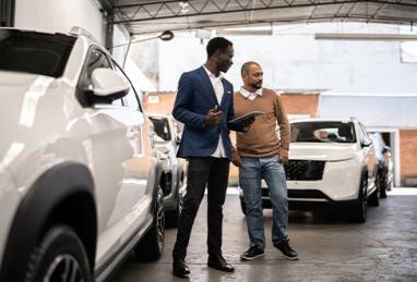 salesman showing car to customer in a car dealership