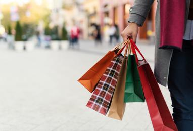 Person holding shopping bags with presents on the street