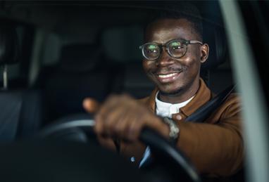 Happy African American businessman driving his car