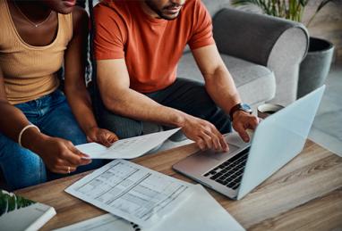 young interracial couple reviewing their paperwork to file their taxes