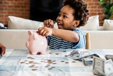 African-American child counting the money in his piggy bank 