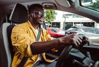 African-American man smiling while driving a car