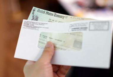 man opening mail, receives tax refund check from the government