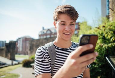 a university student using his phone in a public park