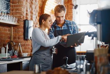 two entrepreneurs discussing business while looking on their laptop