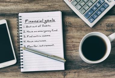 notepad with financial goals and coffee cup