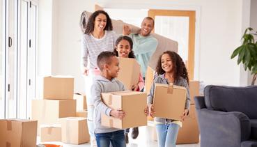 family in house carrying boxes