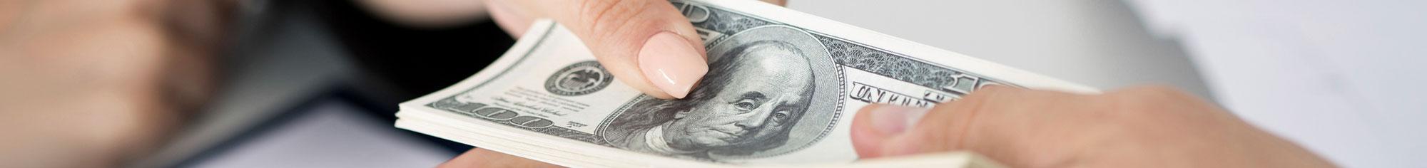 Two people handing off money