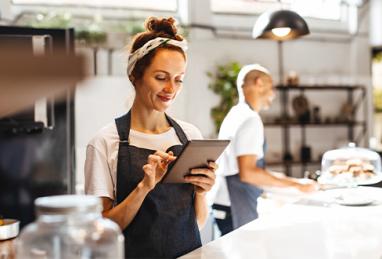 Café waitress using a digital tablet to manage orders
